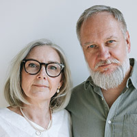 headshot of well-dressed middle-aged woman and man couple facing camera
